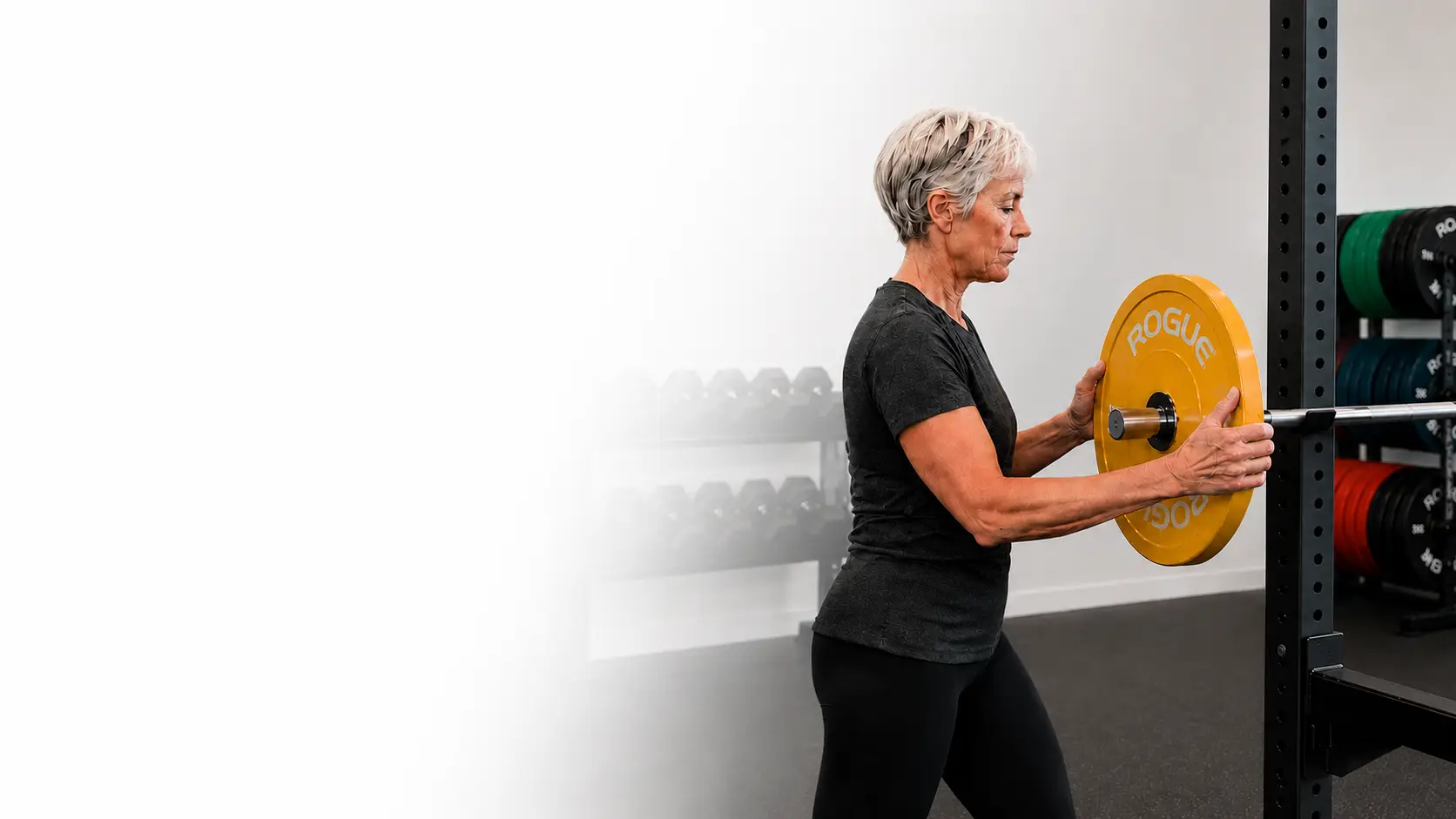 ONERO® promotional image of a woman loading a weight plate onto a racked barbell